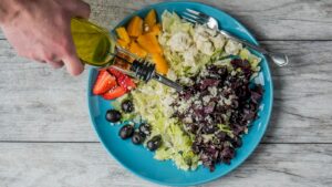 Colorful raw food meal with fruit vegetables nuts seeds and a fresh salad on a bright table
